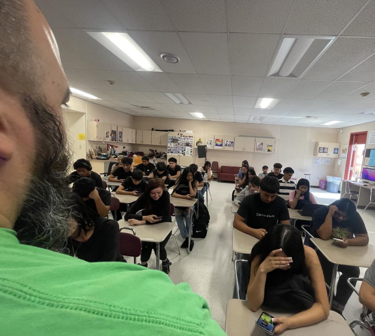 Granite Hills students look at their cell phones while teacher Mr. Flores talks to them during class. 