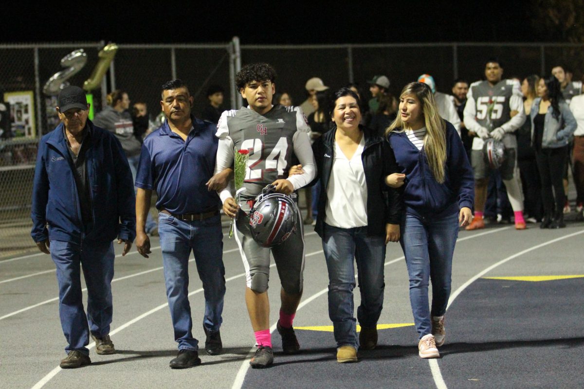 Carlos Zavala walks on the track with his family before beating Lindsay on Senior Night on Oct. 25 at Jacob Rankin Stadium.