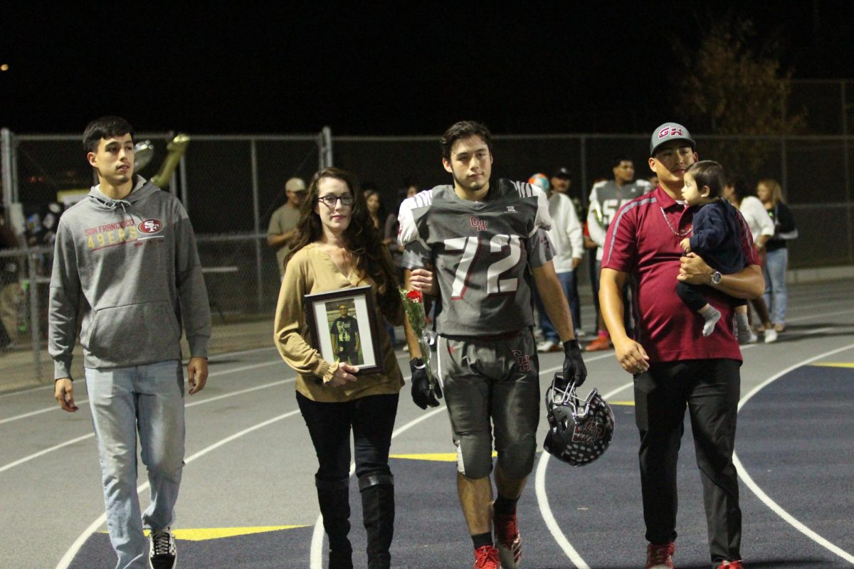 Joseph Ramirez walks on the track with his family before beating Lindsay on Senior Night on Oct. 25 at Jacob Rankin Stadium.