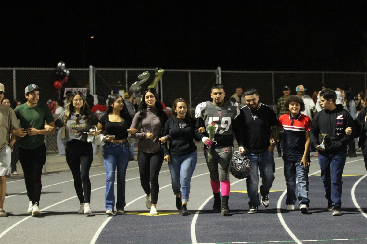 David Jimenez walks on the track with his family before beating Lindsay on Senior Night on Oct. 25 at Jacob Rankin Stadium.