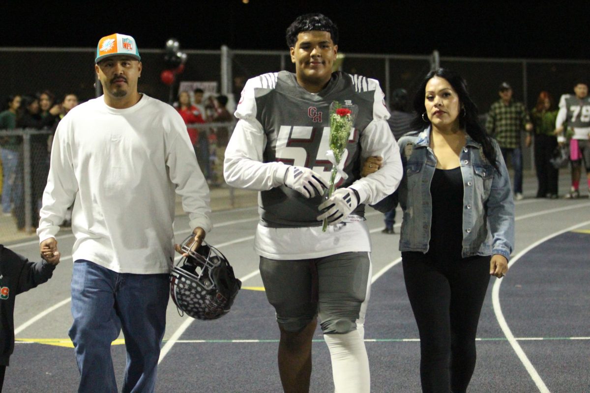 Mark Ellis walks on the track with his family before beating Lindsay on Senior Night on Oct. 25 at Jacob Rankin Stadium.