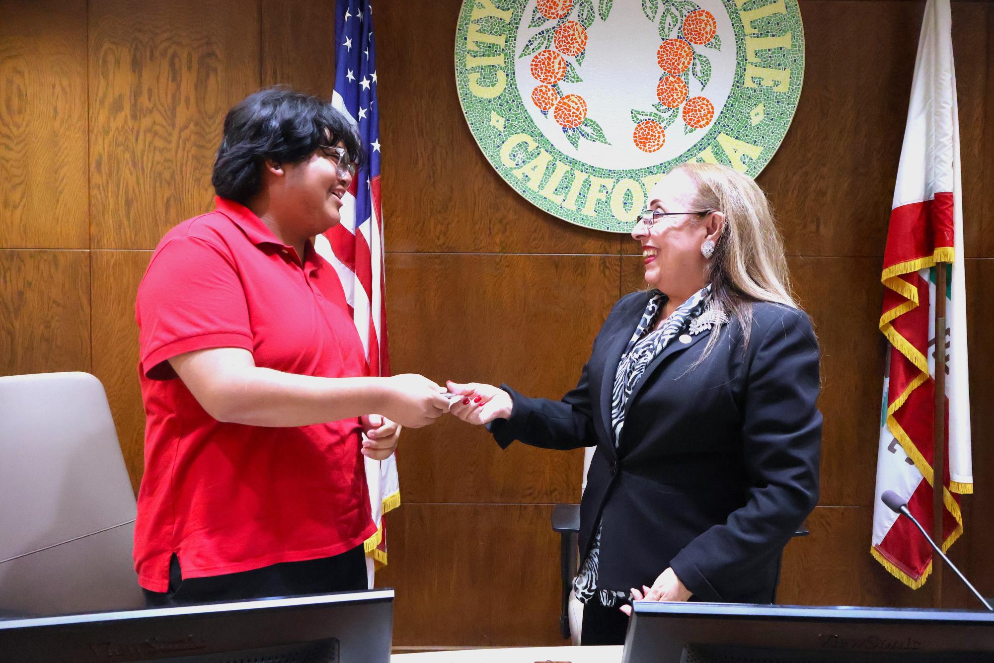 Granite Hills senior Jose Nava is awarded a challenge coin by Porterville Mayor Martha A. Flores. Flores encourages young people to exercise their right to vote in the upcoming election. Nava plans on voting in the upcoming election since he has already turned 18 years old. 