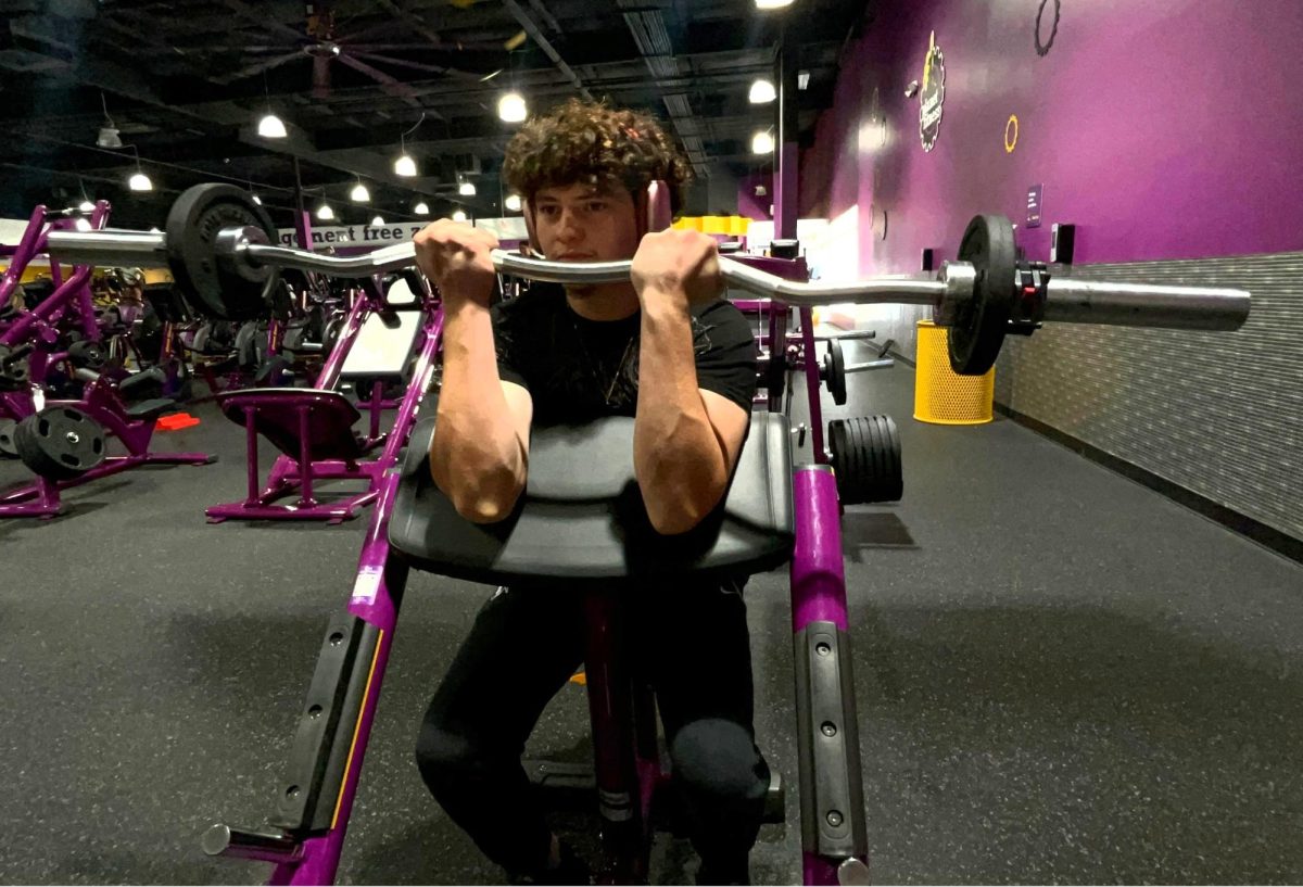 Jesus Jimenez demonstrates the preacher curl workout at a local Planet Fitness gym. 